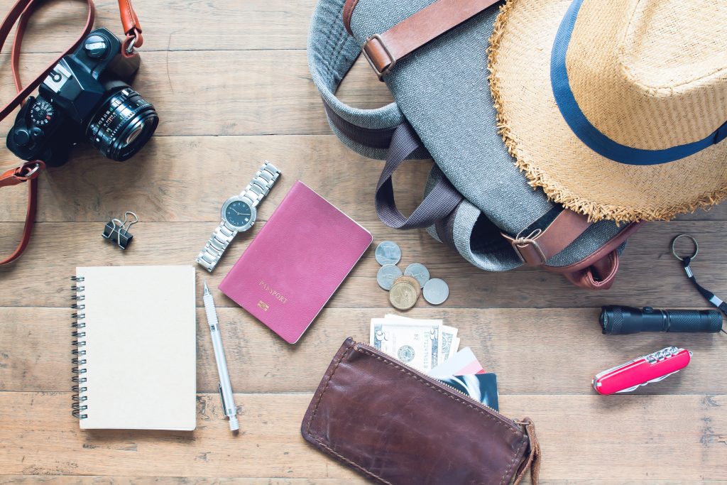 Un lot d'objets de voyage comme un appareil photo, une montre, un passeport, un carnet, de l'argent, un couteau suisse etc